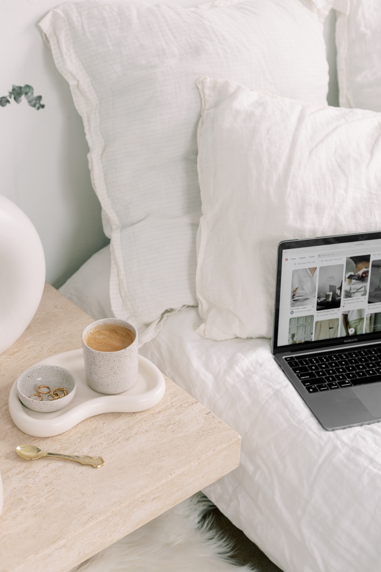 Laptop and coffee on a bedside table for the Glint Marketing blog